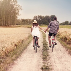 couple on bikes holding hands