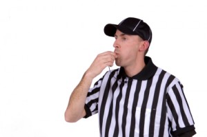 Football referee blowing whistle